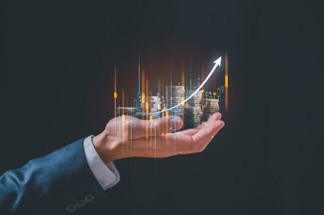 investment and finance concept, businessman holding virtual trading graph and blurred coins on hand, stock market, profits and business growth.
