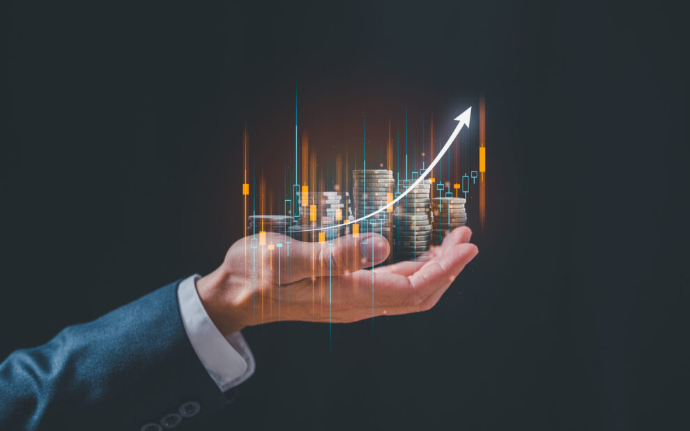 investment and finance concept, businessman holding virtual trading graph and blurred coins on hand, stock market, profits and business growth.